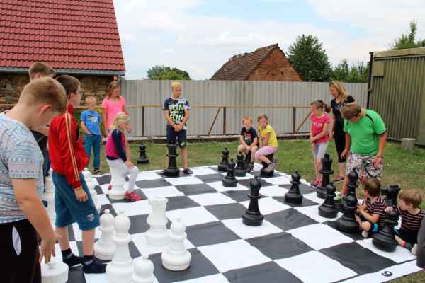 Letní šachové soustředění (Pravonín, 3. - 7. 7. 2017) - Děti hrají partii na  zahradních šachách
FOTO: ŠK Pravonín